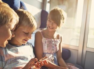 Children seated together on a train. 